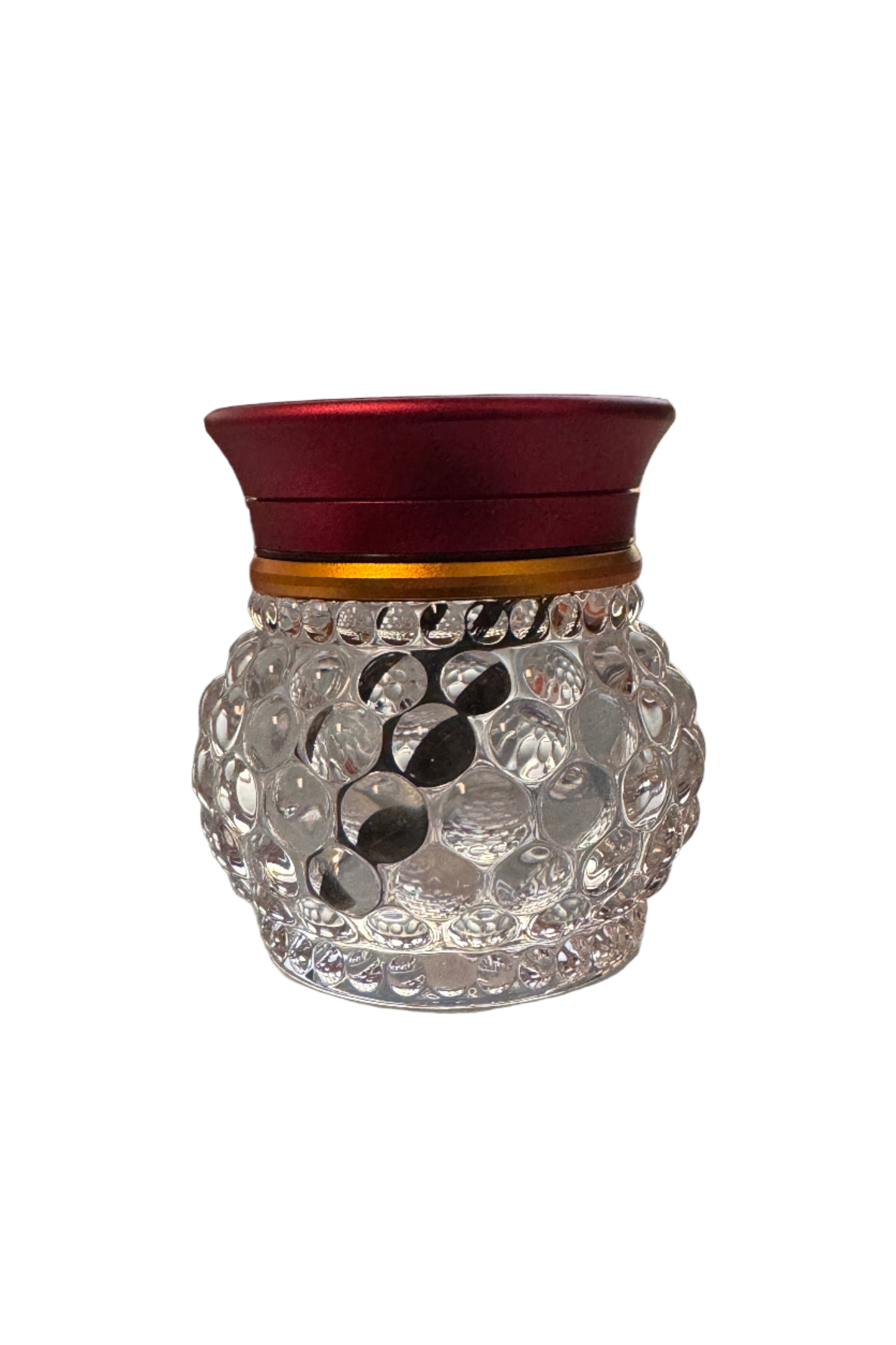 Decorative glass herb grinder on a table with a blurred outdoor background