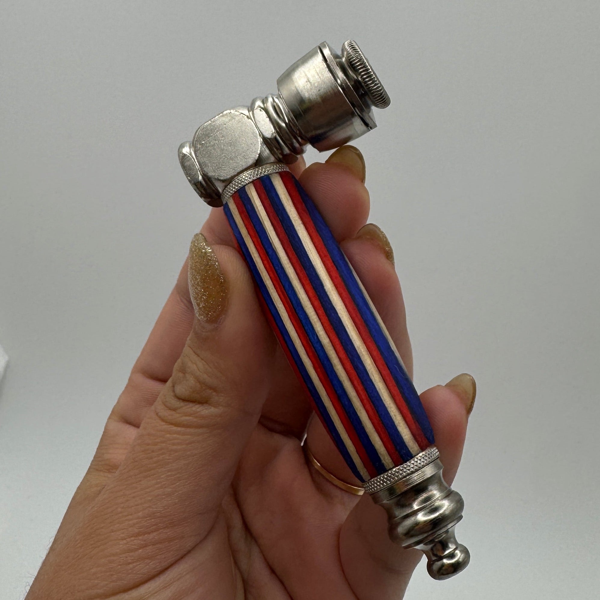 Hand holding a pipe with a striped grip against a white background