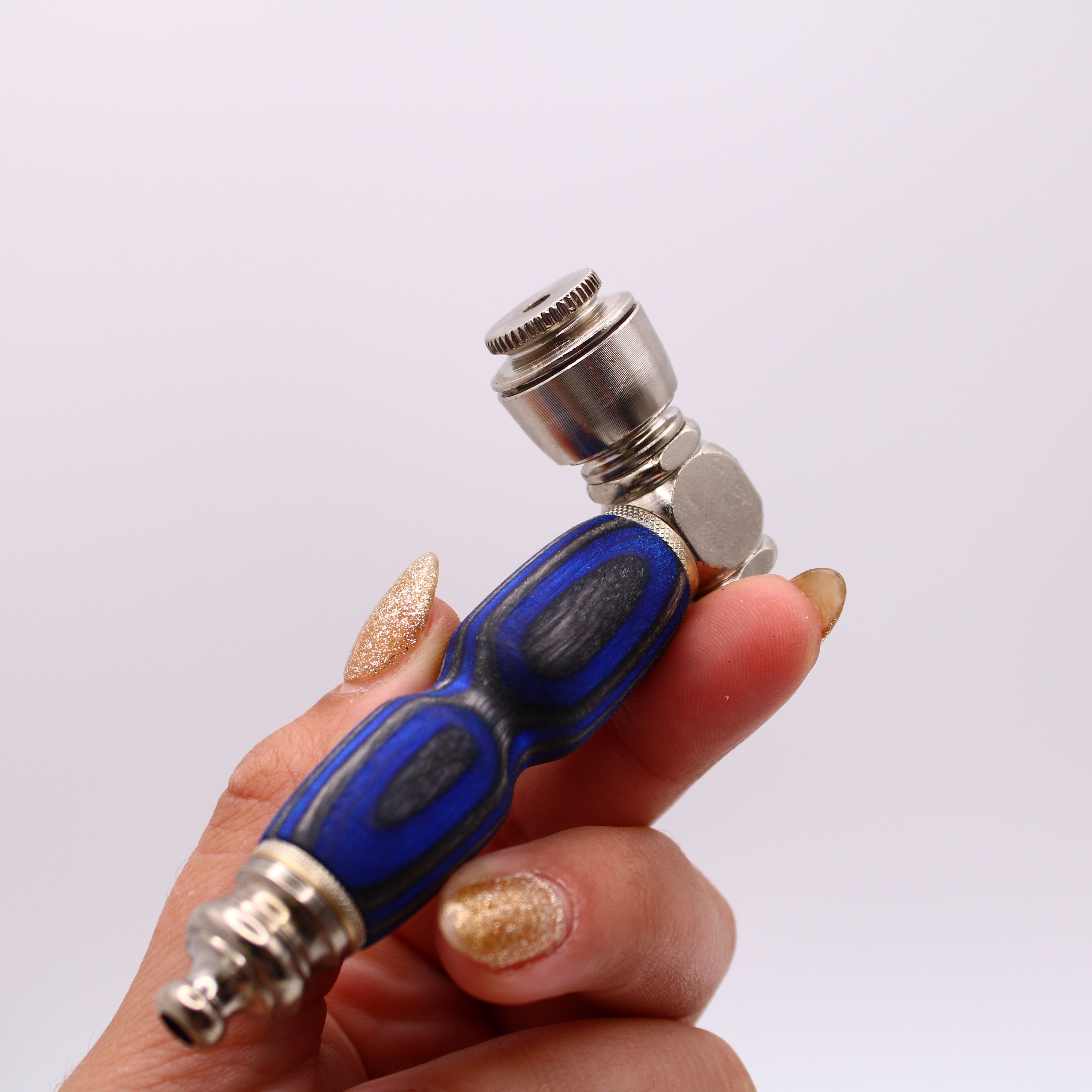 Hand holding a blue and silver tool against a white background