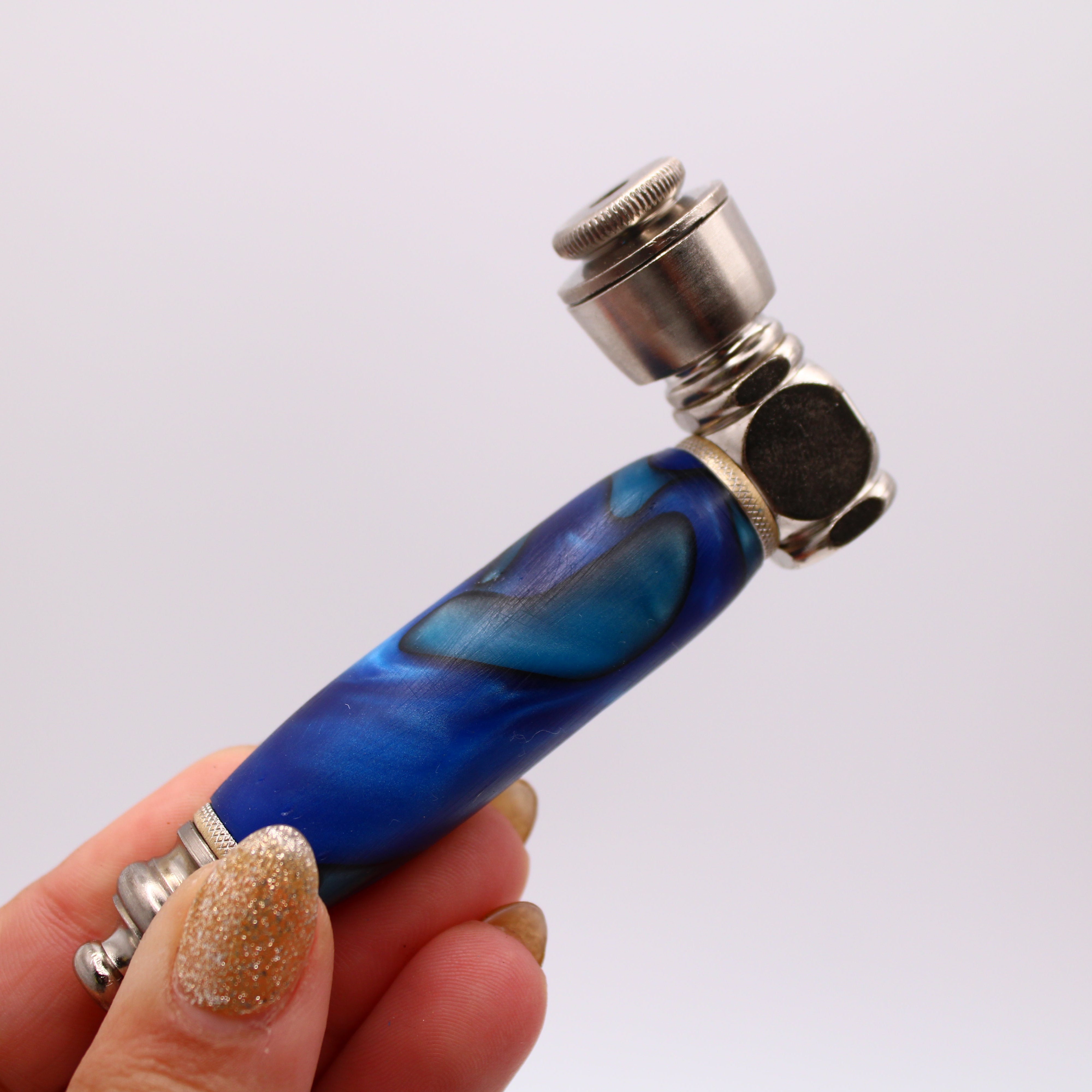 Blue and silver pipe held in a hand against a white background