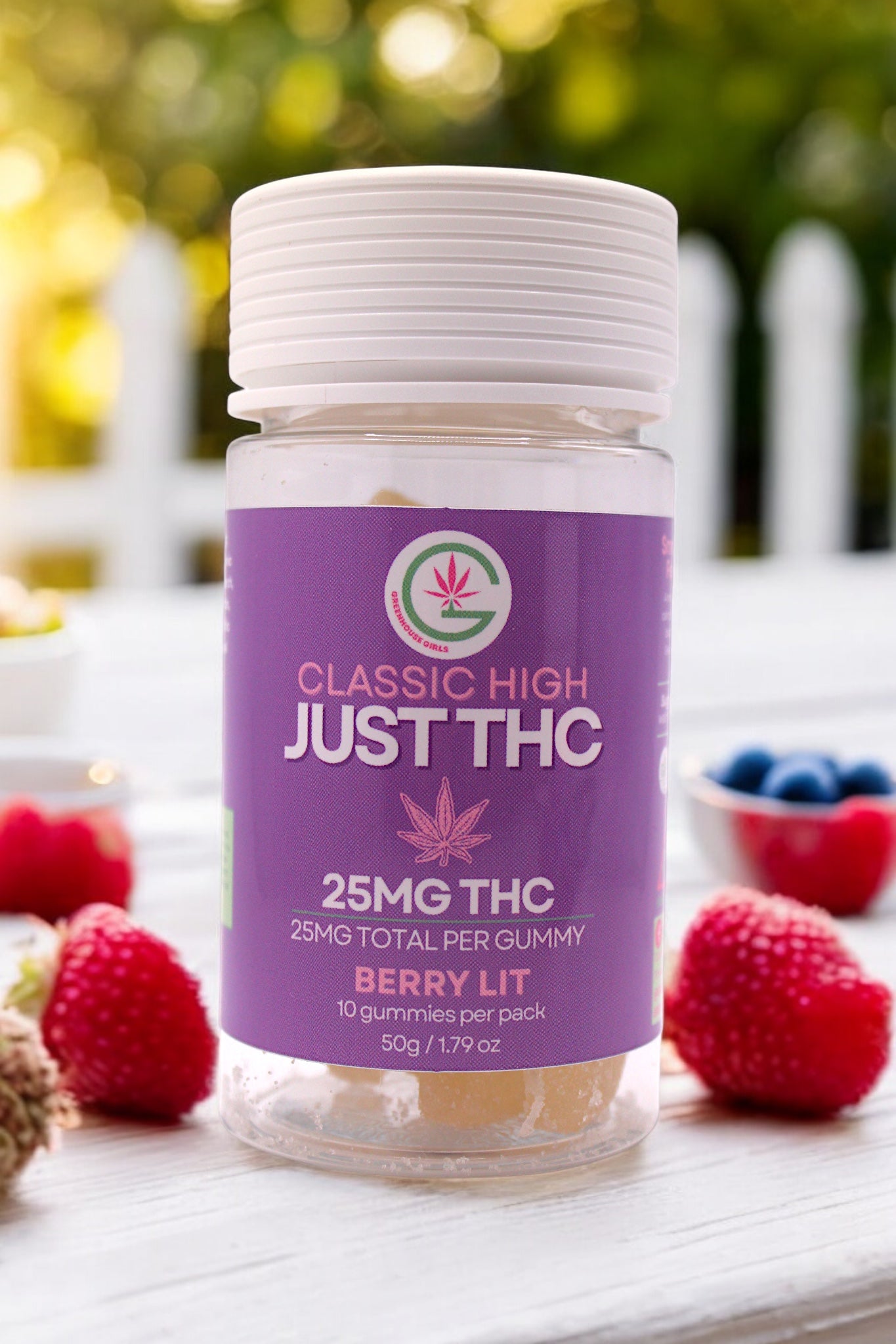 Jar of 'Just THC' gummies with a purple label on a table with berries.