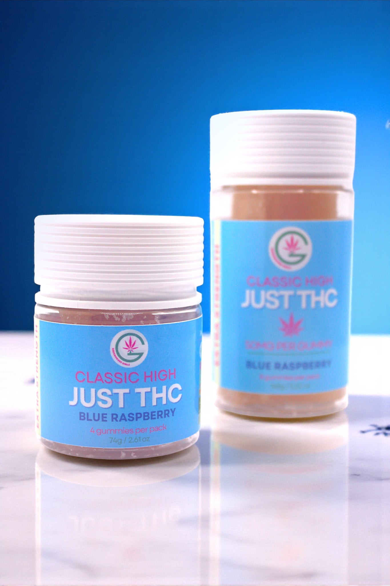 Two jars of 'Just THC' Blue Raspberry flavor on a reflective surface with a blue background