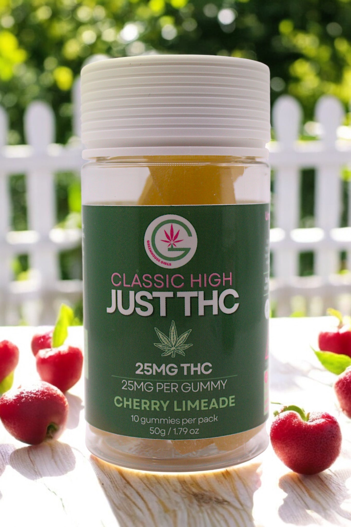 Jar of THC gummies with cherry limeade flavor on a white surface with red fruits.