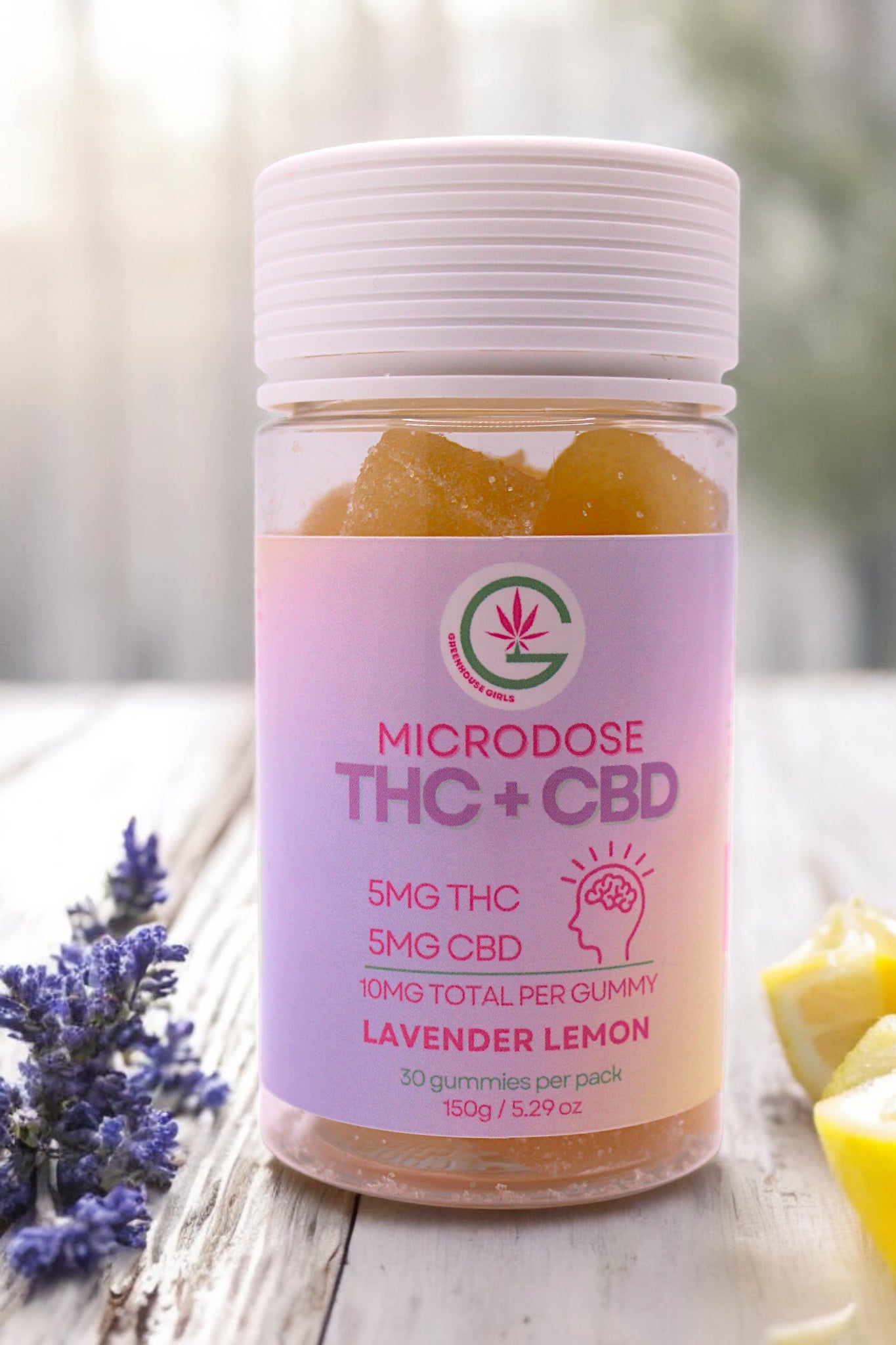 Jar of lavender lemon-flavored microdose THC + CBD gummies on a wooden surface with blurred background