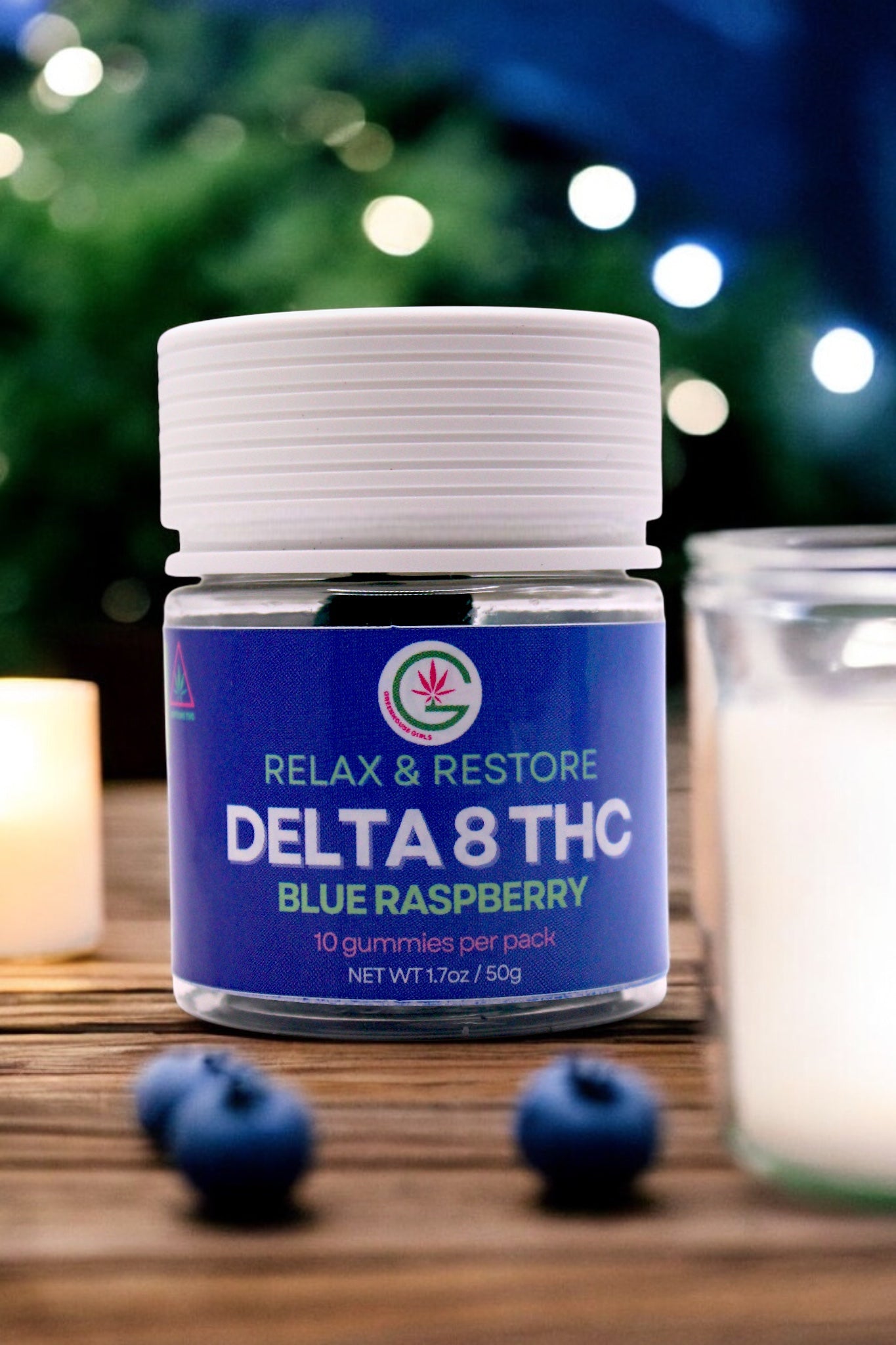 Delta 8 THC Blue Raspberry gummies packaging on a wooden surface with blueberries and candles.