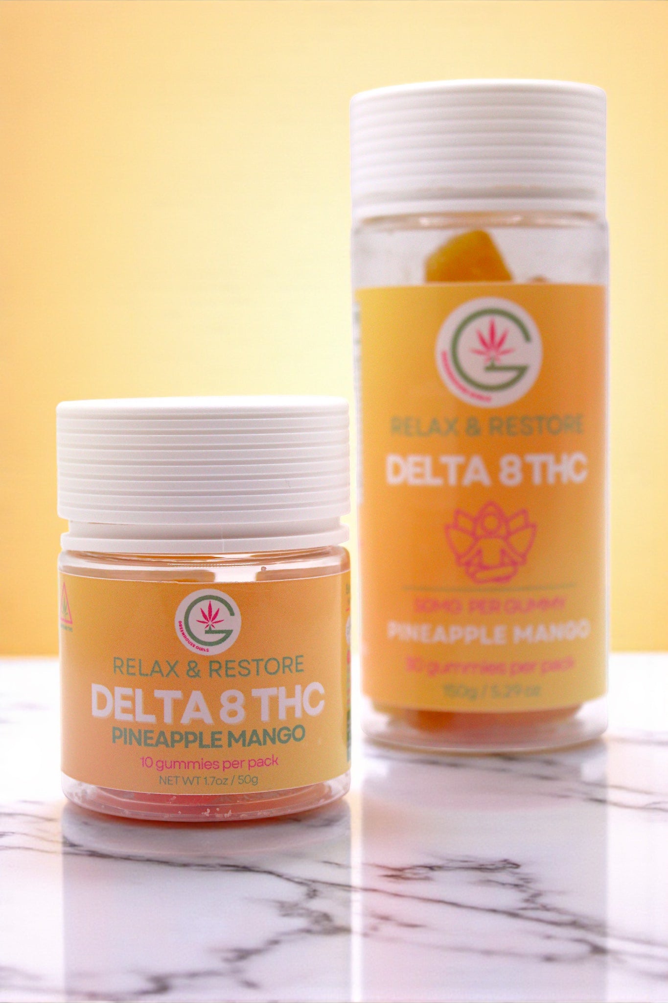 Two jars of Delta 8 THC pineapple mango flavor on a marble surface with a yellow background.