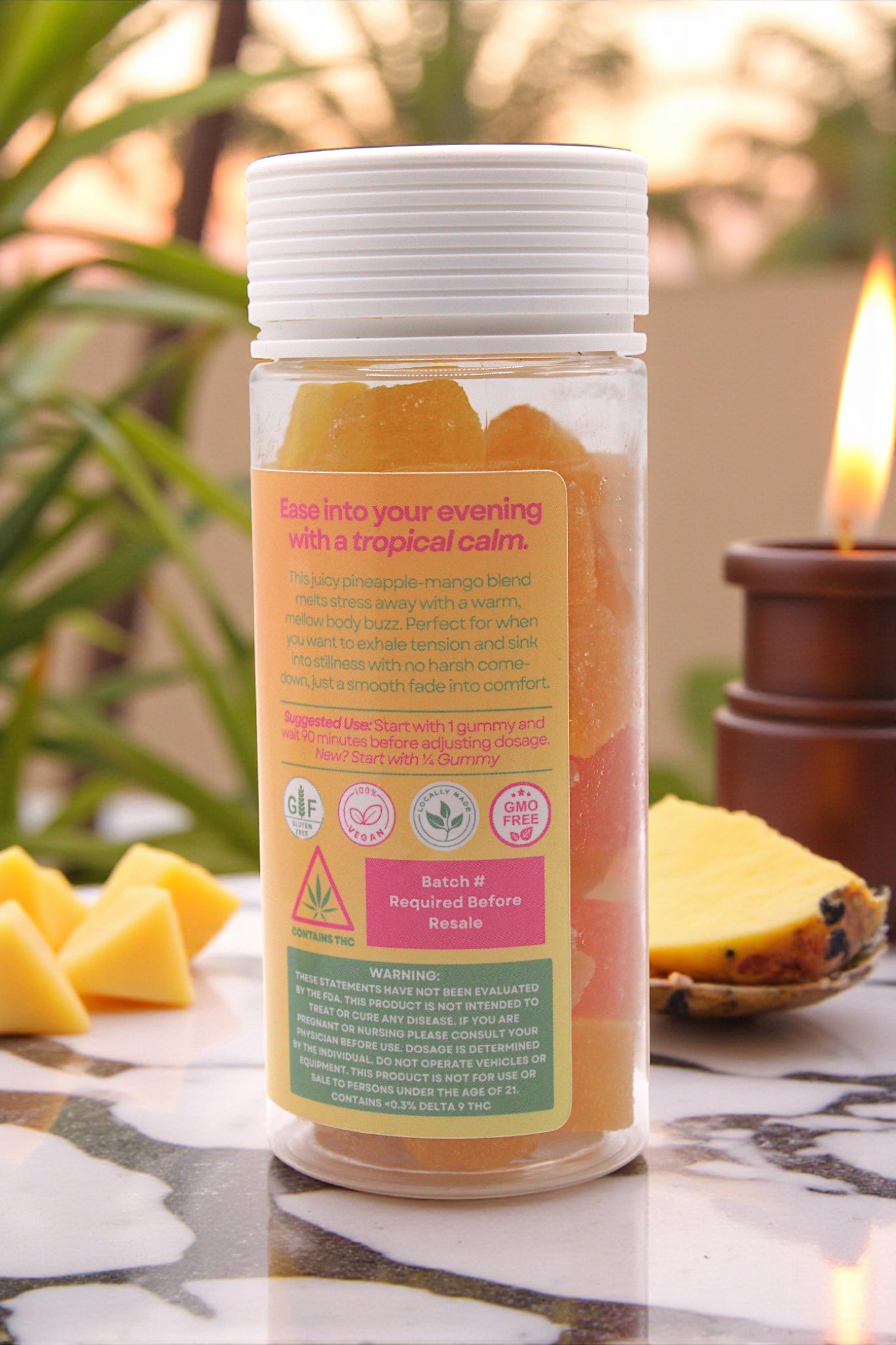 Tropical-themed product packaging with pineapple slices on a decorative surface