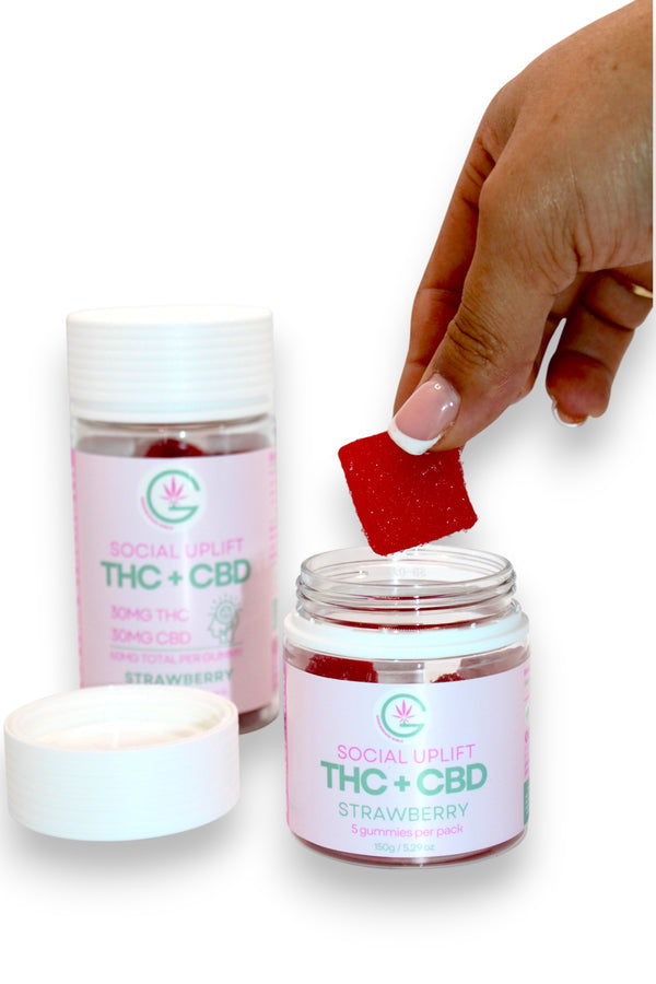 Jar of Social Uplift THC + CBD Strawberry with a hand holding a red strawberry.