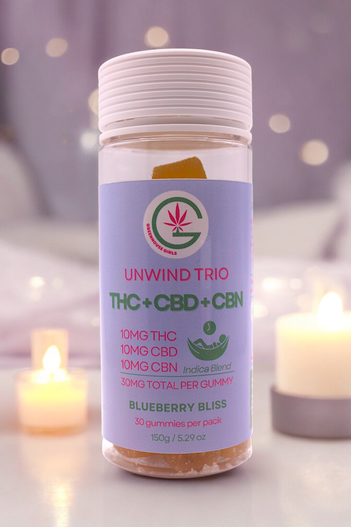 Bottle of Unwind Trio THC+CBD+CBN with candles in the background