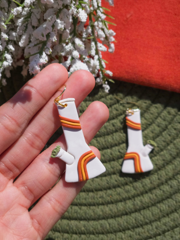 groovy bong cannabis earrings being help in someones hand